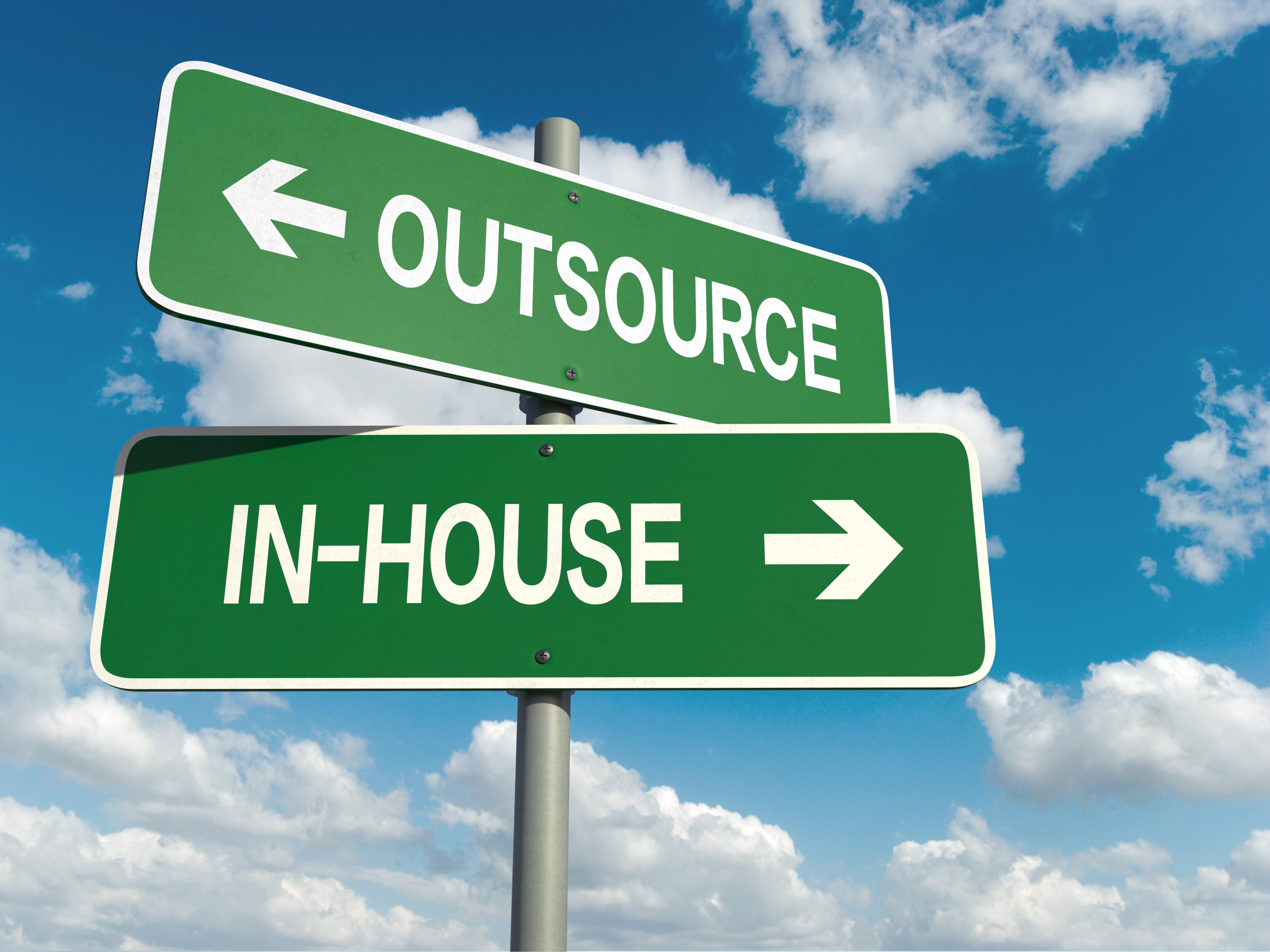 Road signs pointing in opposite directions reading In-house and outsource (licensed from Adobe Stock Photos)